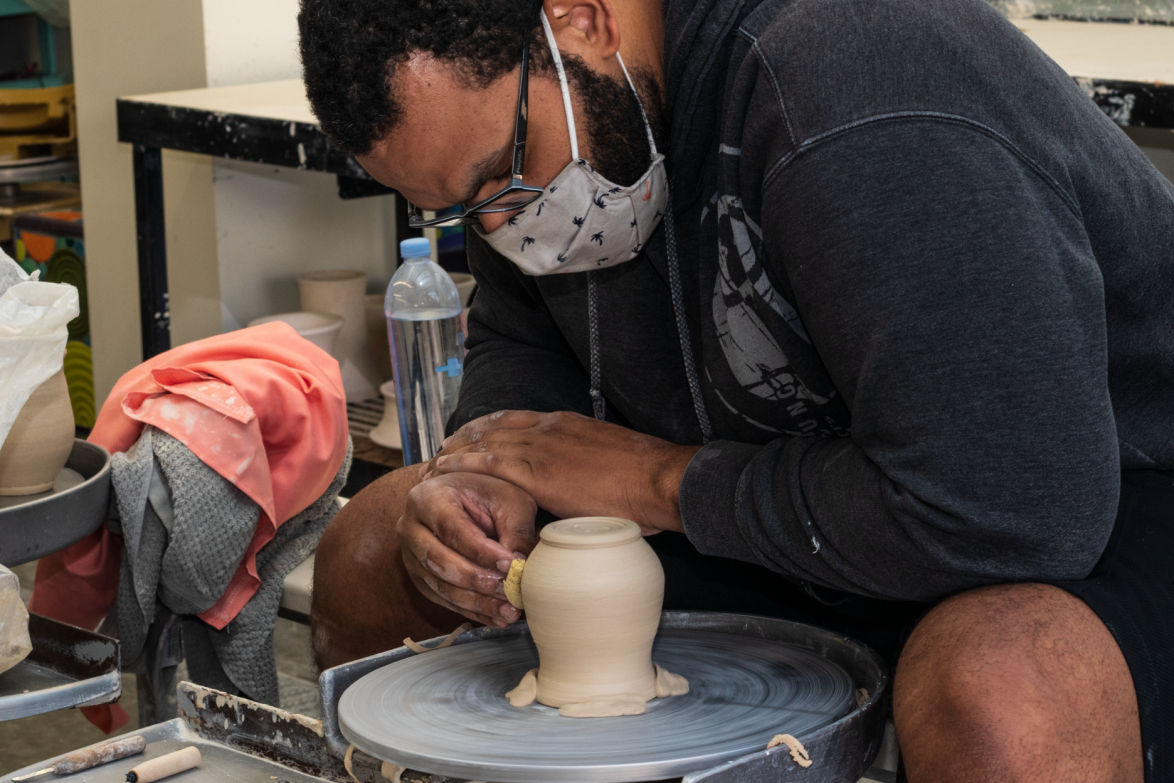 Student working with clay pot on clay wheel in the citrus college ceramic studio