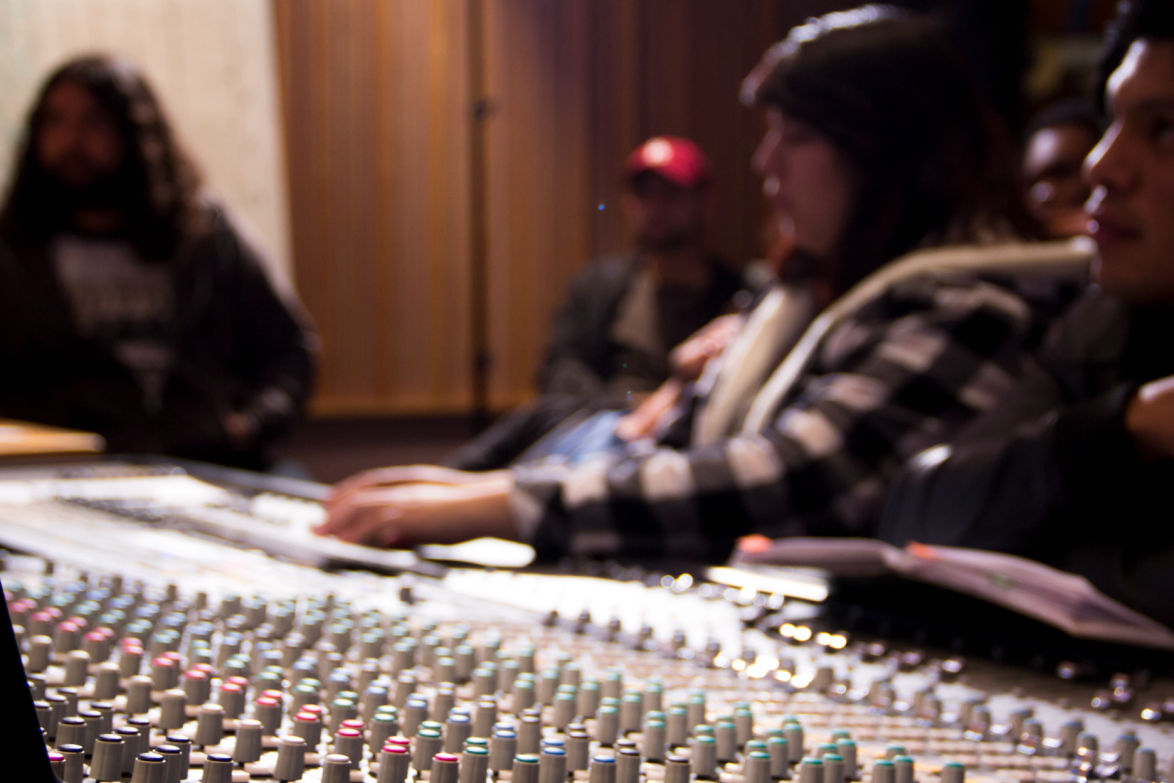students sitting around mixing console in the citrus college recording studio